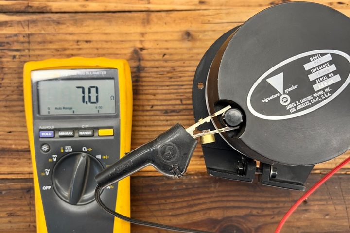 Multimeter connected by clip leads to a vintage JBL tweeter